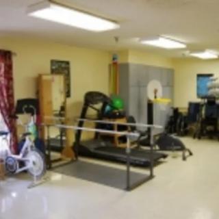A rehabilitation room equipped with various therapy and exercise equipment.