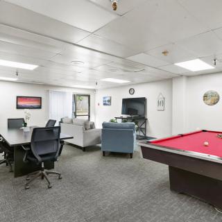 A modern office space featuring a conference area and a pool table.