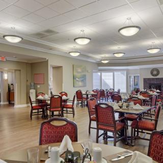 A well-lit dining area with tables and chairs arranged for service.
