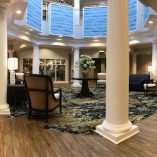 A beautifully designed lobby featuring modern furniture, elegant pillars, and a cozy seating area.