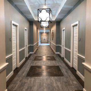 A modern hallway with multiple doors and elegant lighting fixtures.