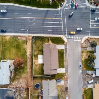 Aerial view of a suburban intersection with houses and cars.