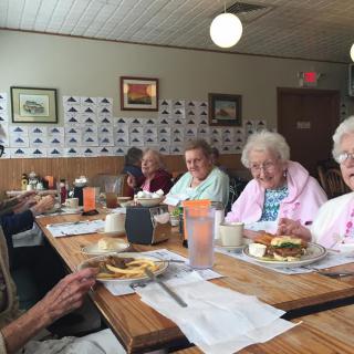 A group of seniors enjoying a meal together at a restaurant.