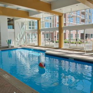 A modern indoor swimming pool with natural light streaming through large windows.