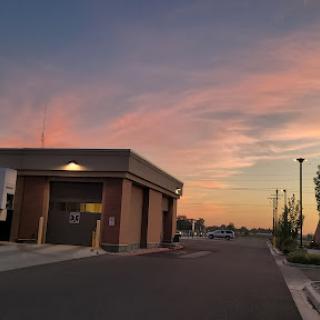 A tranquil evening scene featuring a building under a colorful sunset sky.