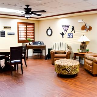 A cozy office space with comfortable seating, a work desk, and warm wood flooring.