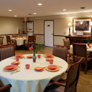 A cozy dining area with elegantly set tables and warm lighting.