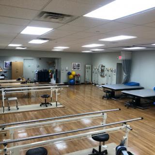 A spacious physical therapy room equipped with various rehabilitation tools and exercise equipment.