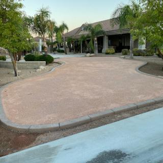 A newly paved driveway leading to a beautifully landscaped residence.