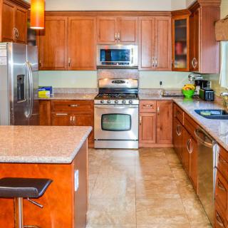 A modern kitchen featuring stainless steel appliances and wooden cabinets.