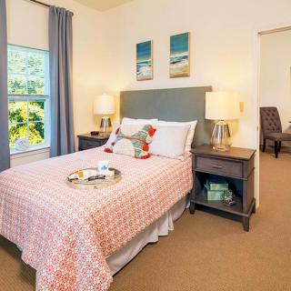 A cozy bedroom with a neatly made bed, tasteful decor, and two bedside lamps.