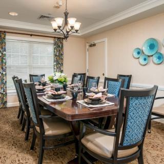 A beautifully decorated dining room with a large table and upholstered chairs.