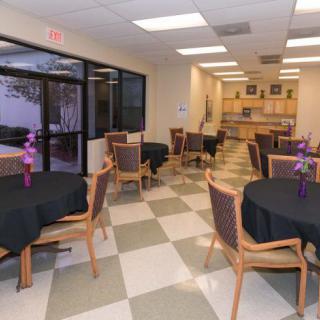 A small dining area with decorated tables and chairs placed on a checkered floor.