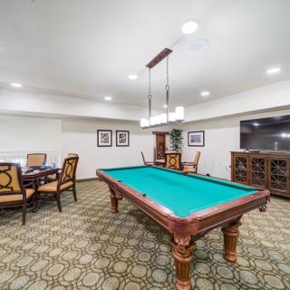 A well-furnished game room featuring a pool table and seating area.