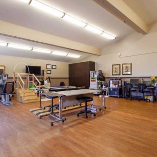 A spacious rehabilitation clinic equipped with various therapy tools and exercise equipment.
