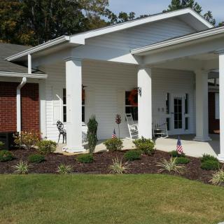 A modern house with a covered porch and well-maintained garden.