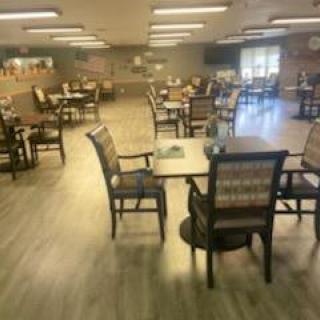 An empty dining area with tables and chairs arranged in a spacious room.