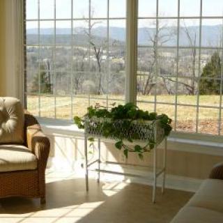 A cozy living room with large windows offering a scenic view of the outdoors.