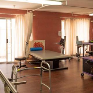 A well-equipped physical therapy room with various exercise equipment and apparatus.