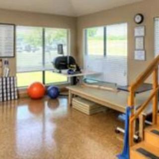 A physical therapy room equipped with exercise balls and a treatment table.