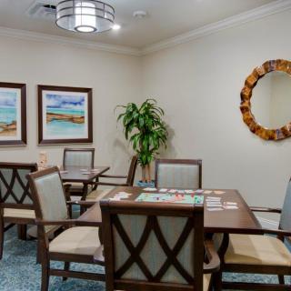 A cozy dining area with a wooden table, cushioned chairs, abstract artwork, and a decorative mirror.