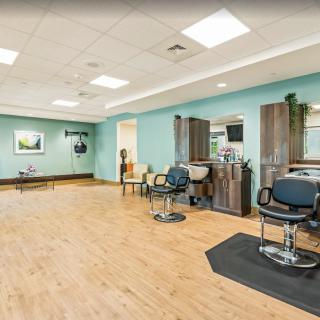A modern hair salon interior with barber chairs and mirrors.