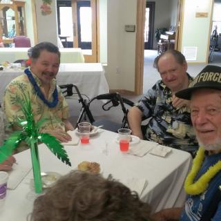 A group of elderly individuals enjoying a festive indoor gathering with decorations and drinks.