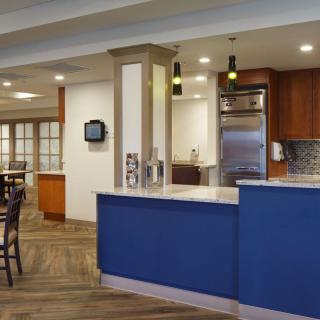 A modern kitchen and dining area with a blue counter and wooden accents.