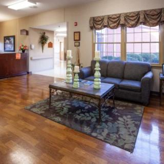 A cozy living room with a sofa, coffee table, and wooden flooring.