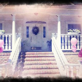 A welcoming house entrance decorated with balloons and a wreath.