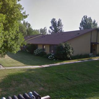 A suburban house with a well-maintained lawn and surrounding trees.