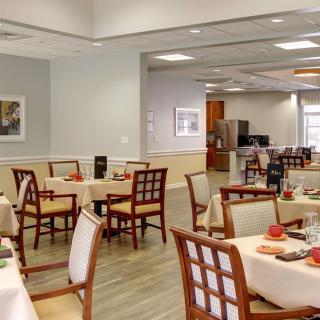 A well-lit dining area with neatly arranged tables and chairs.