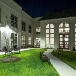 A well-lit courtyard at night with benches and a modern building.