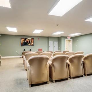 A cozy theater room with plush seating and a projector screen.