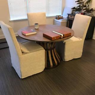 A cozy dining setup featuring a round wooden table and upholstered chairs.