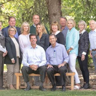 A cheerful group gathered for a photo in a beautiful outdoor setting.