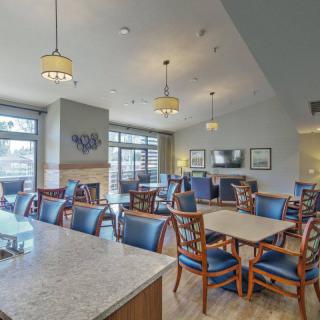 A modern dining area with multiple tables and chairs, featuring elegant lighting and contemporary decor.