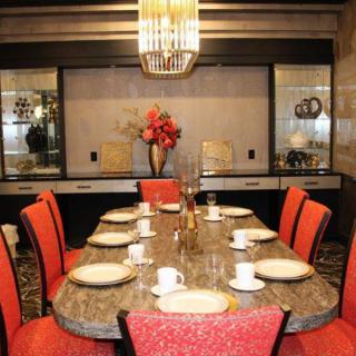 An elegantly decorated dining room with a set table and vibrant red chairs.