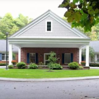 A traditional brick house with a covered entrance and well-maintained garden.
