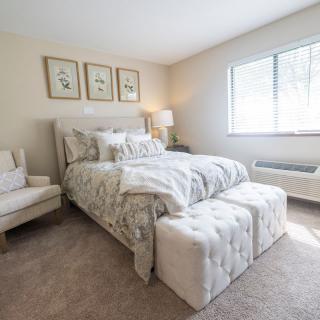A cozy and elegantly decorated bedroom with a comfortable bed, soft lighting, and stylish furniture.