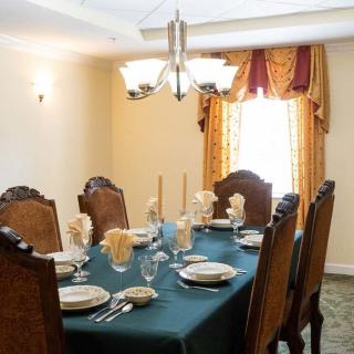 An elegantly set dining table with wooden chairs and a chandelier in a formal dining room.