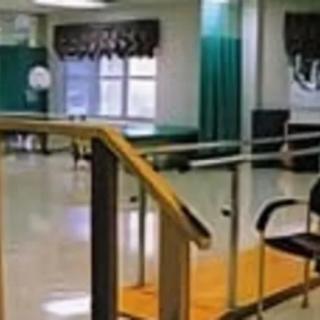 A physical therapy room equipped with exercise facilities and parallel bars.