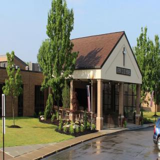 A picturesque church building surrounded by trees on a sunny day.