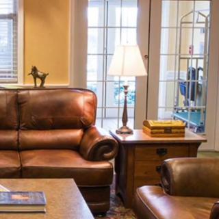 A cozy living room with leather seating, a wooden coffee table, and a lamp providing soft lighting.