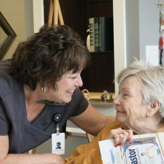 A caregiver interacting warmly with an elderly resident, showcasing the importance of companionship in healthcare.
