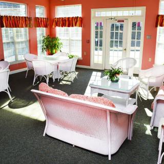 A bright living room with pink furniture and large windows letting in sunlight.
