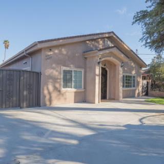 A charming residential house with a welcoming front entrance and sunny surroundings.