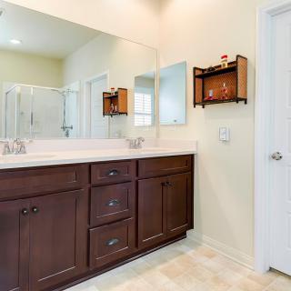 A modern bathroom featuring a wooden vanity with a large mirror and sink.
