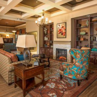 A beautifully decorated living room featuring a cozy fireplace, elegant furniture, and vibrant artwork.