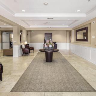 A spacious and elegantly decorated lobby area with comfortable seating and a centerpiece table displaying flowers.